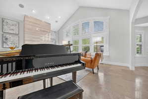 Living area featuring arched walkways, a high ceiling, and recessed lighting