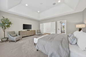 Bedroom with carpet flooring, a tray ceiling, and recessed lighting