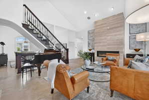 Living area featuring a fireplace, arched walkways, and vaulted ceiling