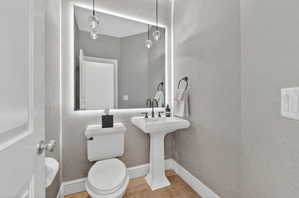 Bathroom with light tile patterned floors and a textured wall
