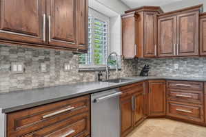 Kitchen with dishwasher, wood finish cabinetry, and decorative backsplash