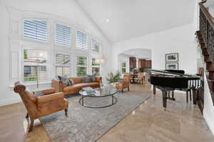 Living area with arched walkways, recessed lighting, and lofted ceiling