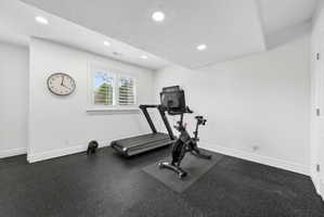Exercise room featuring a textured ceiling, rubber floors, and recessed lighting