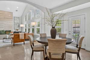 Dining area with lofted ceiling and recessed lighting