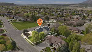 Aerial view of residential area with property boundaries highlighted and a mountain backdrop