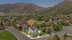 Aerial perspective of suburban area featuring property boundaries highlighted and a mountainous background