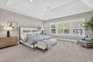 Bedroom with a tray ceiling, light carpet, and recessed lighting