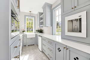 Bar area featuring pendant lighting, gray cabinetry, oven, open shelves, and plenty of natural light
