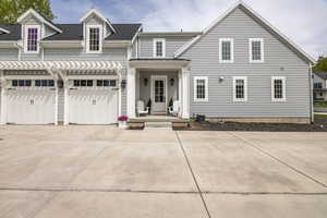 View of front of home with a porch, roof with shingles, and concrete driveway
