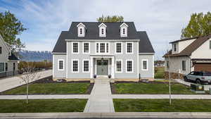 View of front of house featuring a shingled roof, a front lawn, and a mountain view