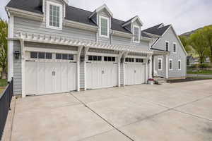 View of front of house featuring a shingled roof and driveway