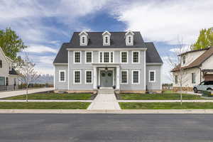 View of front of home with a front yard and roof with shingles