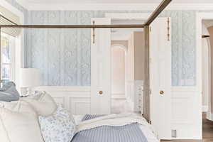 Bedroom with wallpapered walls and arched walkways