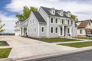 View of front of house featuring driveway, a shingled roof, a front lawn, and an attached garage