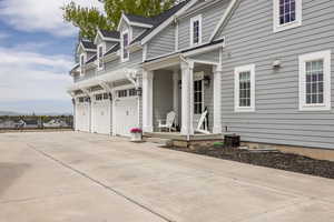 Entrance to property featuring driveway, a shingled roof, and covered porch