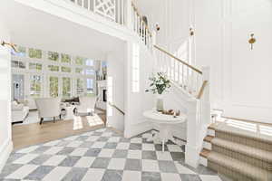 Staircase with a decorative wall, a high ceiling, and a fireplace