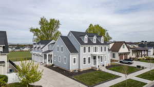 View of front of home with driveway, a residential view, a front yard, and a shingled roof