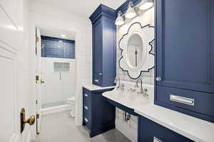 Full bath with vanity, light tile patterned floors, a shower stall, and tile walls