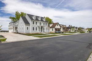 View of front of property featuring a residential view, concrete driveway, and a garage