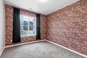 Empty room with brick wall and carpet