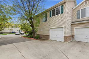 View of side of home featuring brick siding, an attached garage, and concrete driveway