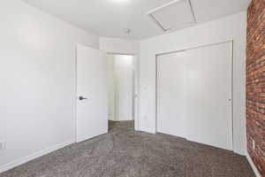 Unfurnished bedroom with dark carpet and a closet