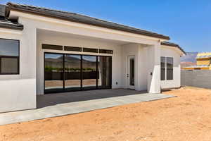 Property entrance featuring a mountain view, a patio, stucco siding, and a tiled roof