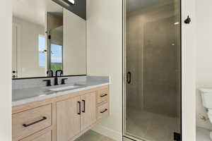 Bathroom featuring vanity, a stall shower, and light tile patterned floors