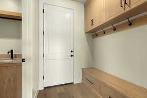 Mudroom featuring light wood-type flooring and a sink