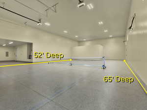 Garage featuring electric panel and recessed lighting