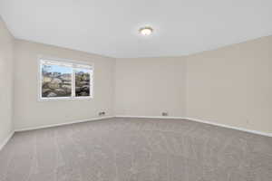 Unfurnished room featuring baseboards and light colored carpet