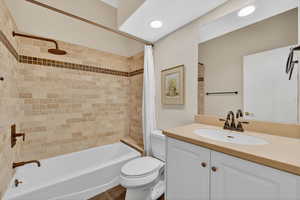 Bathroom with vanity, shower / tub combo, and recessed lighting