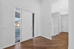 Foyer entrance with dark wood-type flooring and recessed lighting