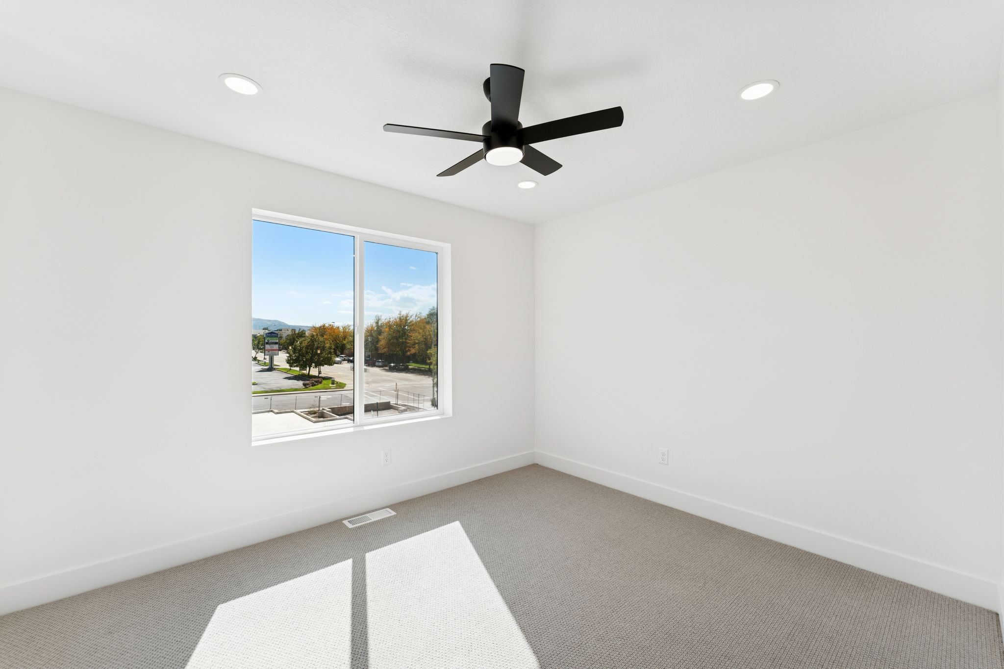 Spare room with carpet floors, a ceiling fan, and recessed lighting