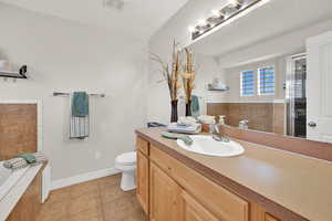 Bathroom featuring vanity, light tile patterned flooring, a garden tub, and a shower with door