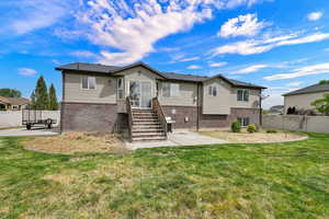 Back of house with a patio area and brick siding