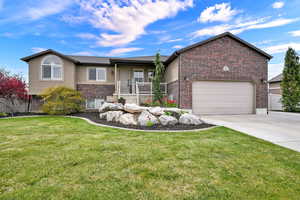 Ranch-style home featuring a garage, brick siding, concrete driveway, a porch, and a front yard
