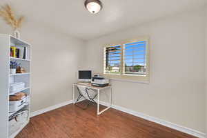 Office with a textured ceiling and dark wood-style floors