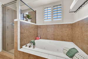 Full bath with a whirlpool tub and a shower stall