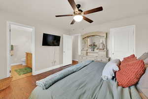 Bedroom with connected bathroom, wood finished floors, a ceiling fan, and a textured ceiling