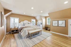 Bedroom with light wood-style flooring, recessed lighting, and vaulted ceiling