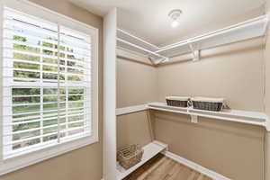 Walk in closet with light wood-style flooring