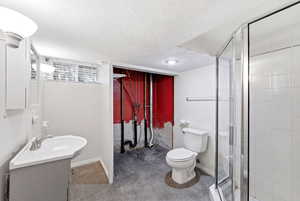 Bathroom with vanity, a textured ceiling, light carpet, and a stall shower