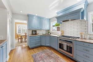 Kitchen featuring blue cabinets, stainless steel appliances, plenty of natural light, and recessed lighting