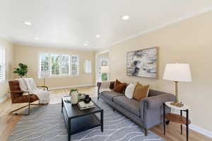 Living area featuring light wood-style flooring, ornamental molding, and recessed lighting