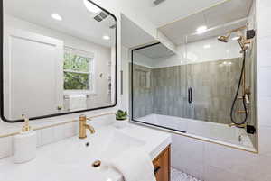 Full bathroom featuring tiled shower / bath combo, vanity, and recessed lighting