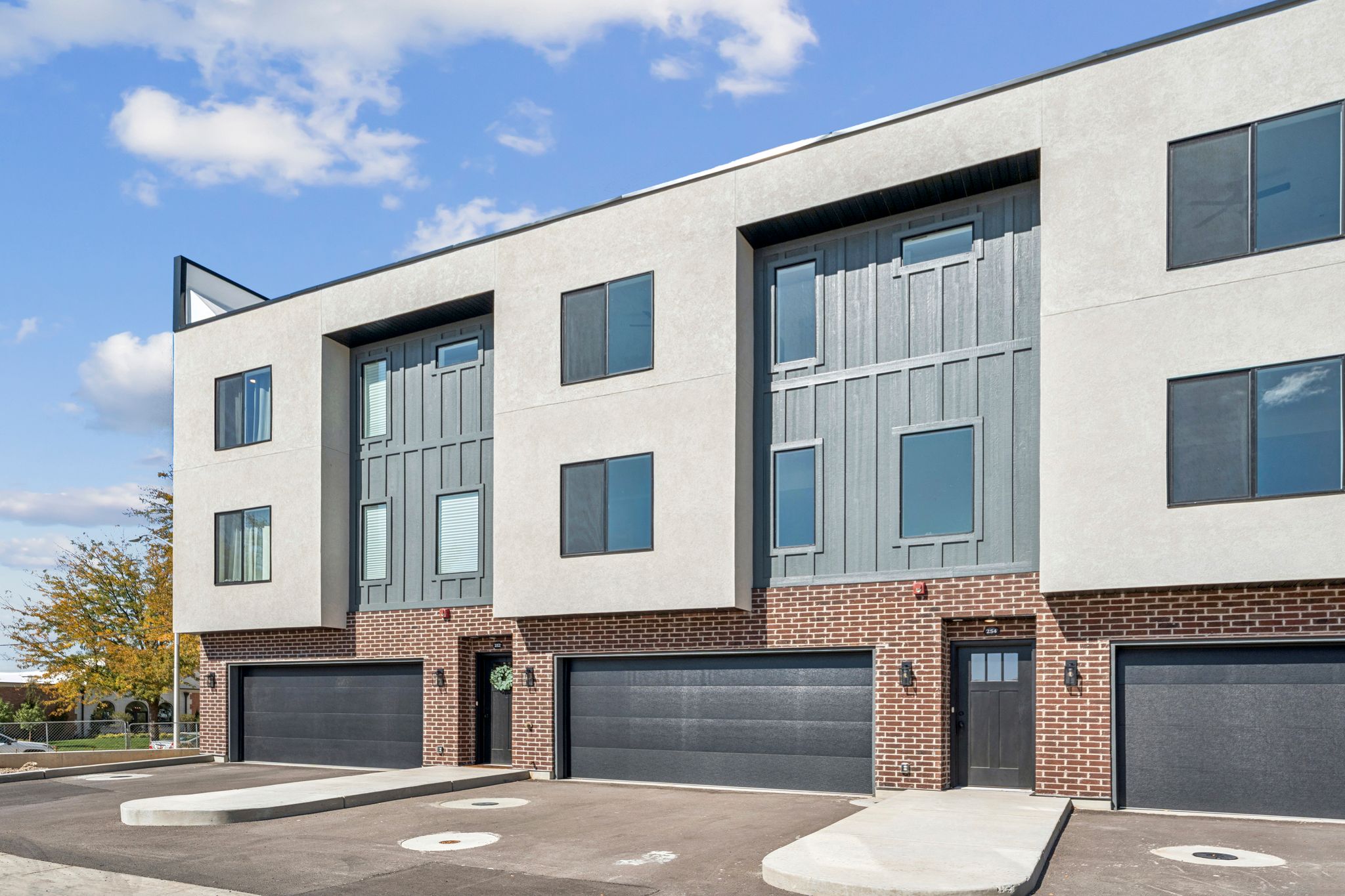 View of building exterior featuring a garage and driveway