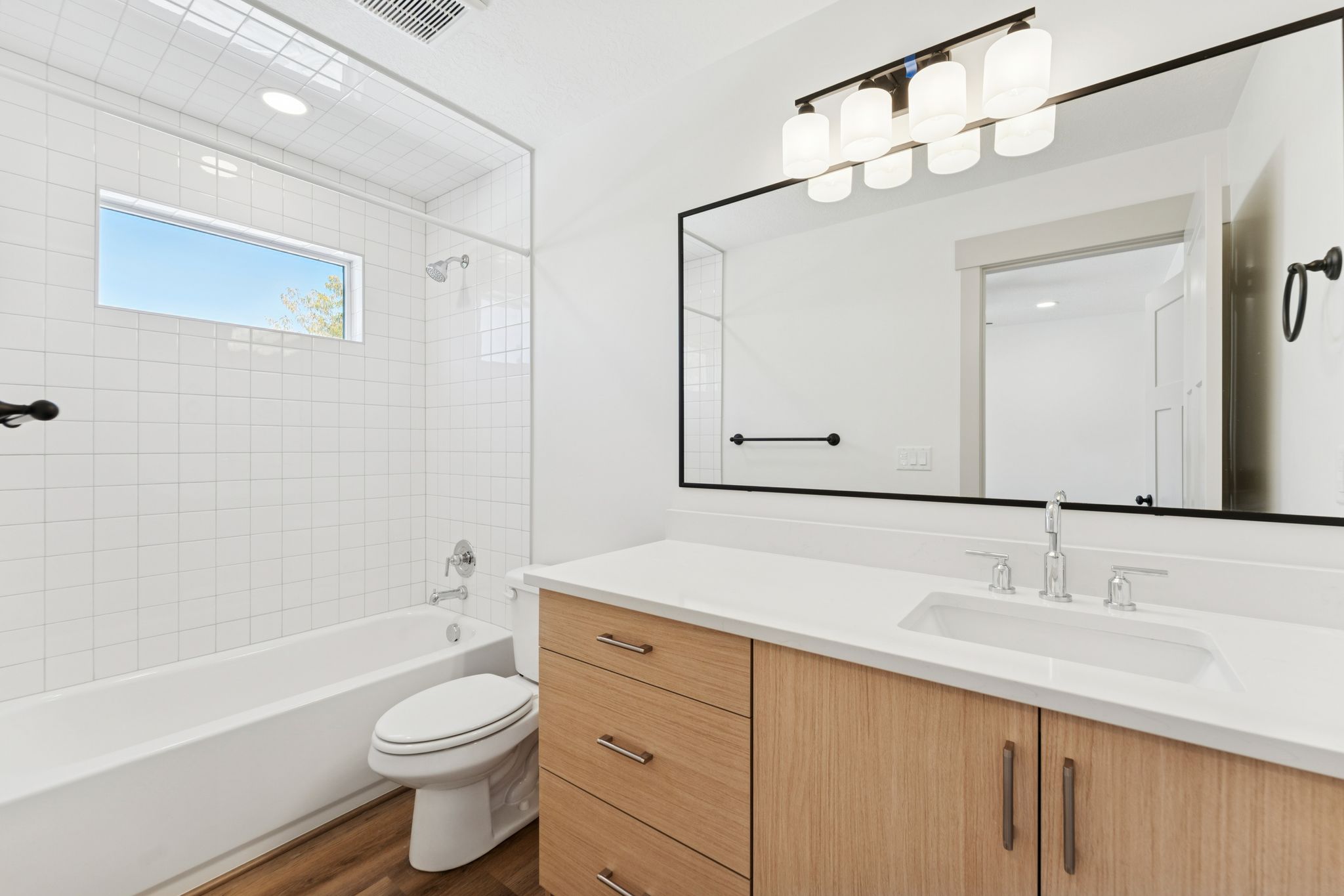 Bathroom featuring vanity, shower / bath combination, and dark wood finished floors