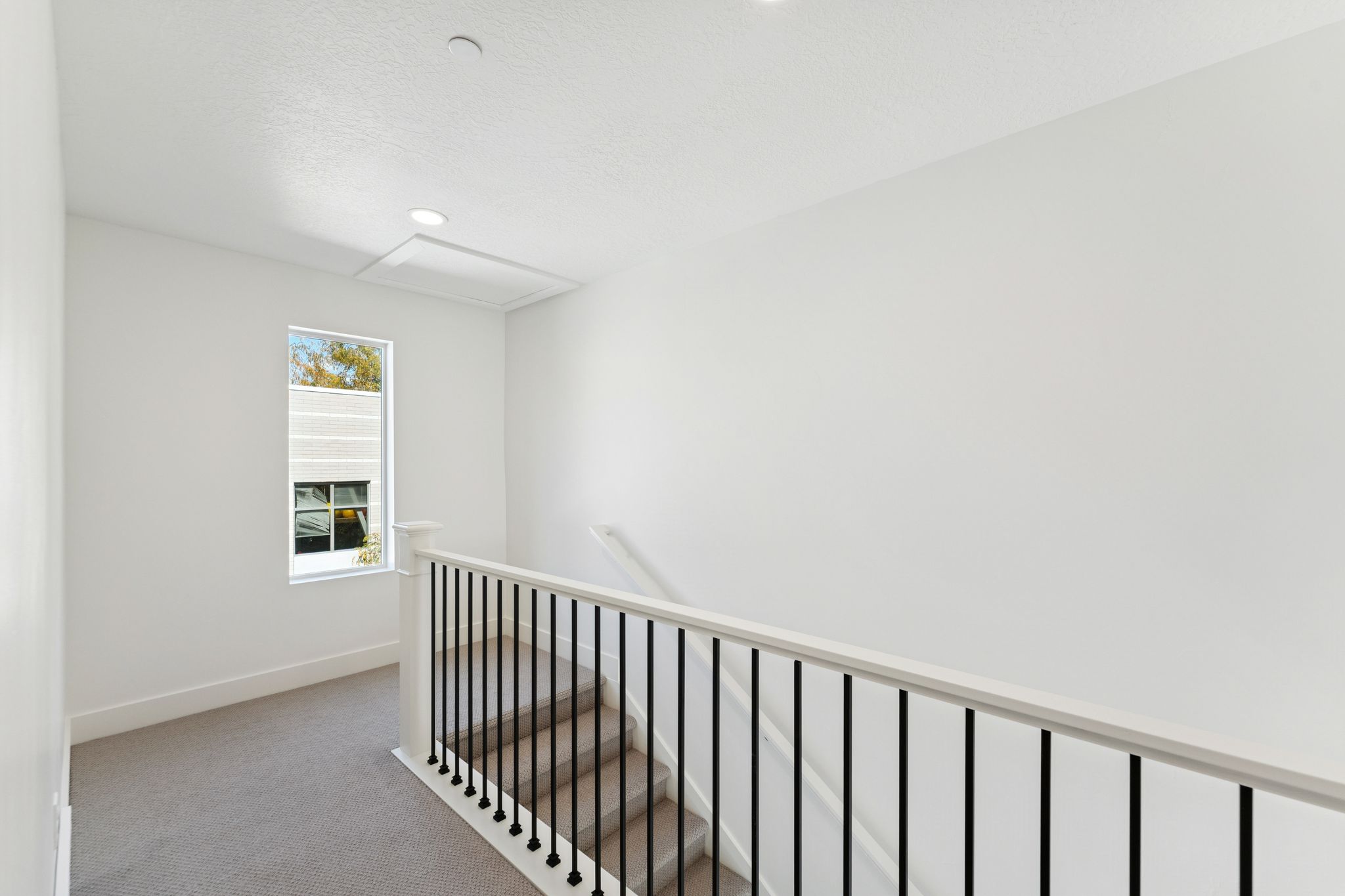 Corridor featuring light carpet and an upstairs landing