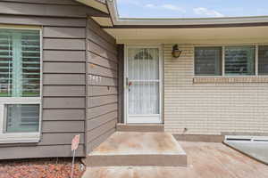 Doorway to property featuring brick siding